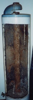 A cut opened water heater showing its rusted inside.