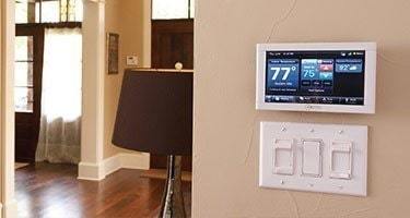 Smart Home panel affixed on a wall above three light switches