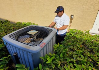 Advanced Air HVAC technician inspecting an outdoor AC unit
