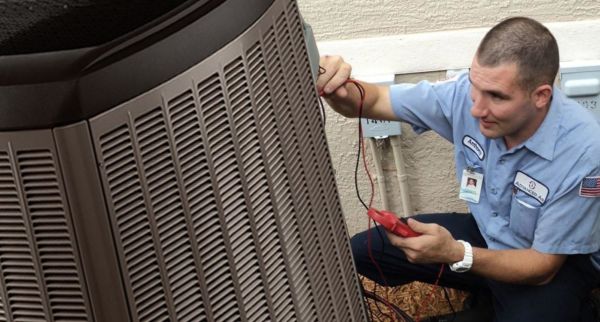 Advanced Air HVAC technician inspecting an outdoor AC unit