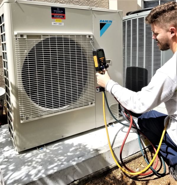 Technician using a diagnosing tool to check a Daikin unit