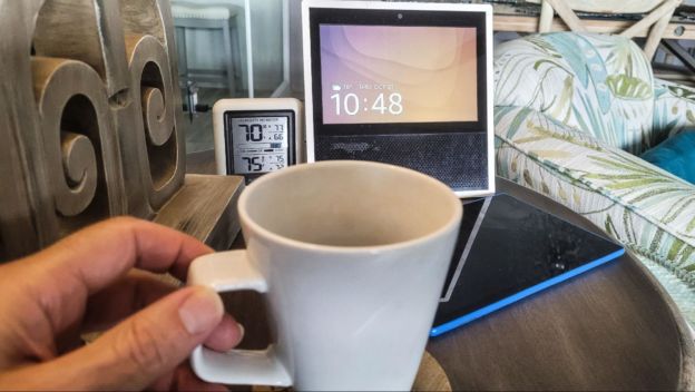 Hand holding a mug, checking the temperature & humidity level