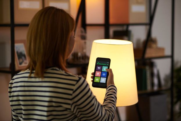 Woman adjusting her smart lights with a smartphone app