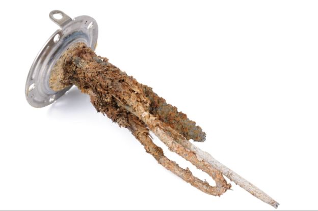 A closeup view of a rusted water heater anode rod