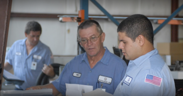 Two Advanced Air techs reviewing paperwork together in warehouse