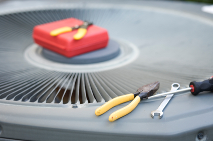 Closeup of an outdoor ac unit top with tools sitting on top